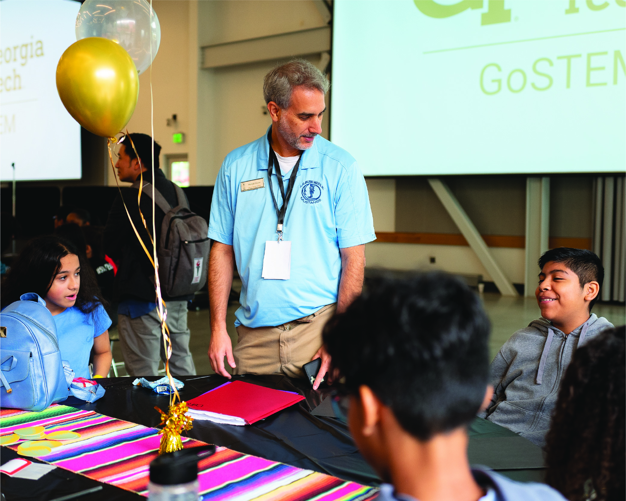 adult talking with smiling students