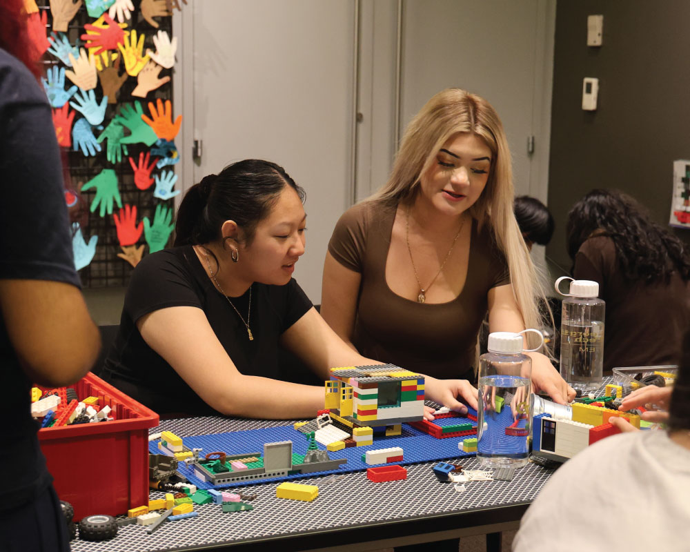 two students working on a LEGO block activity
